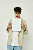 portrait of a young man posing with a white sheet of paper isolated background unaltered photo