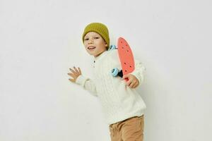 Portrait of happy smiling child girl posing skateboard entertainment light background photo