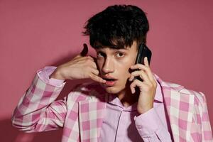 portrait of a young man plaid blazer fashion modern style talking on the phone model studio photo