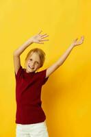 cheerful girl with blond hair gesturing with her hands yellow background photo