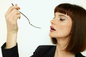 portrait of a woman in a black jacket a knife and a fork near the face isolated background photo