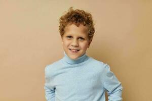 curly boy in a blue sweater posing fun childhood unaltered photo