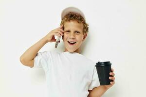 pequeño chico hablando en el teléfono con un negro vaso ligero antecedentes inalterado foto