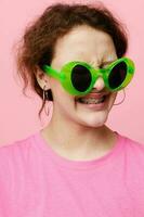 Stylish teenager girl model fashion green glasses pink t-shirt decoration posing photo