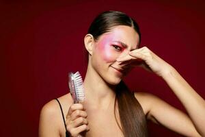 Portrait of beautiful young woman pink face makeup posing attractive look with a comb close-up unaltered photo