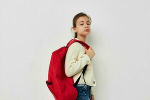 pretty young schoolgirl with red backpack posing isolated background photo