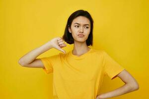 young woman in yellow t-shirt posing fashion yellow background photo