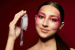 bonito mujer con un peine en mano brillante maquillaje posando Moda emociones estudio modelo foto