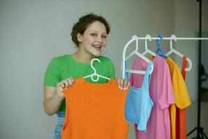 beautiful woman green t-shirts near clothes hangers isolated backgrounds unaltered photo