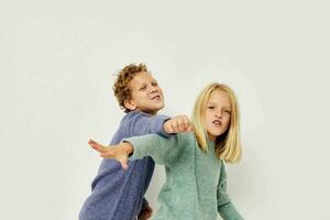 Photo of two children gesticulate with their hands together isolated background