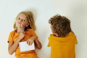 two joyful children drawing fun games with notepad childhood lifestyle unaltered photo
