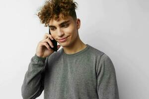 hermoso joven hombre hablando en el teléfono posando emociones aislado antecedentes foto