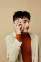 foto joven novio en un beige chaqueta hablando en el teléfono estilo de vida inalterado