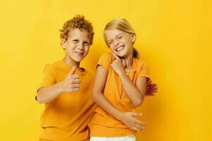 Cute preschool kids cuddling fashion childhood entertainment yellow background unaltered photo