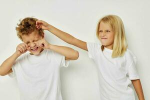 Portrait of cute children in white T-shirts are standing next to childhood unaltered photo