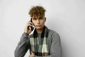 Attractive man in a plaid scarf talking on the phone posing emotions isolated background photo