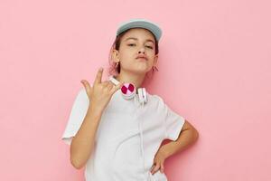 bonito joven niña auriculares en un blanco camiseta y un gorra infancia inalterado foto