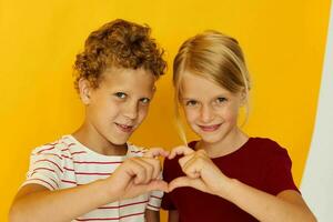 Portrait of cute children cuddling fashion childhood entertainment on colored background photo