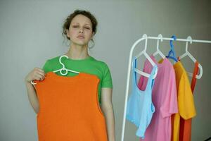 portrait of a young woman ironing clothes on a hanger wardrobe cropped view unaltered photo