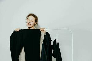 cheerful woman in a suit gestures with his hands wardrobe light background unaltered photo