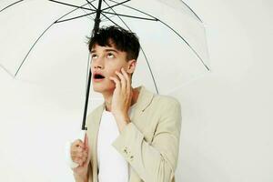 nice young guy with an open umbrella in a suit light background photo