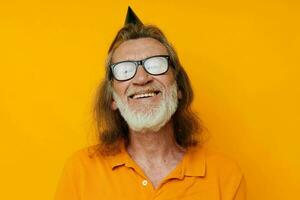 Portrait elderly man in a yellow t-shirt with a cap on his head fun cropped view photo