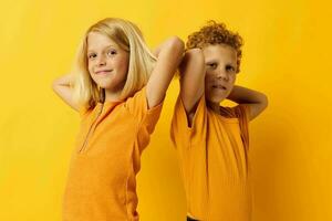 two joyful children casual wear games fun together posing on colored background photo