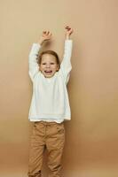 Portrait of happy smiling child girl in white sweater posing hand gestures Lifestyle unaltered photo