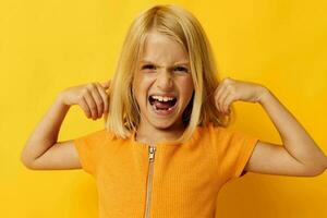 cute little girl in a yellow t-shirt smile posing studio color background unaltered photo