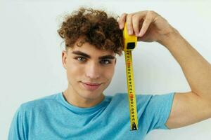 handsome young man blue t-shirt measuring tape posing isolated background photo