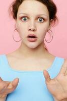 pretty woman grimace close-up emotions earrings posing pink background unaltered photo