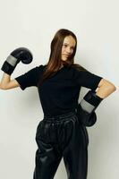 photo pretty girl in black sports uniform boxing gloves posing isolated background