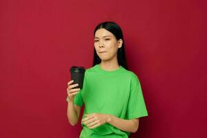 woman with Asian appearance smile green t-shirt black disposable cups fashion isolated background unaltered photo