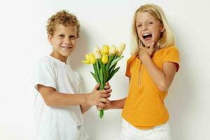 picture of positive boy and girl holiday friendship with a gift Yellow flowers light background photo