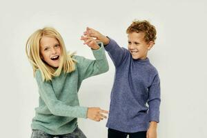 Portrait of cute children in multi-colored sweaters posing for fun light background photo