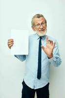 Photo of retired old man in a shirt with a tie copy-space sheet of paper isolated background