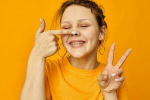 funny girl gestures with hands grimace emotions yellow background unaltered photo