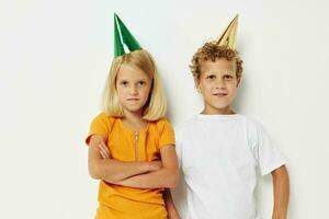 Portrait of cute children posing emotions holiday colorful caps light background photo