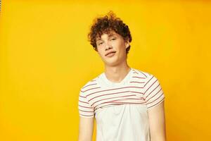 portrait of a young curly man in a white t-shirt holds a striped t-shirt fashion youth style Lifestyle unaltered photo