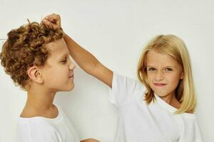 Cute stylish children in white T-shirts are standing next to Lifestyle unaltered photo