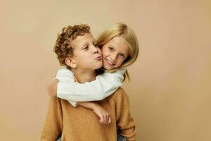 pequeño chico y niña en pie siguiente a posando emociones aislado antecedentes foto