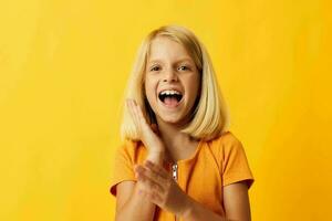 linda pequeño niña con rubio pelo posando amarillo antecedentes foto