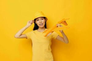 pretty brunette in a hat with an airplane in his hands model toy isolated background unaltered photo