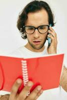 Cheerful man talking on the phone red notepad isolated background photo