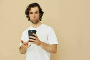Attractive man in a white T-shirt with a black glass in hand Lifestyle unaltered photo