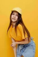 photo pretty woman posing in a yellow T-shirt and cap isolated background