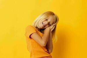 kid girl in a yellow t-shirt smile posing studio color background unaltered photo