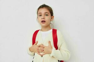 cute schoolgirl with red backpack posing isolated background photo