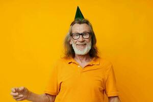 Senior grey-haired man fun birthday cap on the head isolated background photo