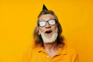retrato de contento mayor hombre divertido cumpleaños gorra en el cabeza aislado antecedentes foto